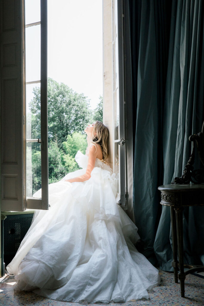 Bride and groom embracing in soft natural light, with warm highlights on the bride’s skin and elegant bridal earrings.